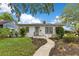 Charming home featuring a curved walkway to the front door, mature landscaping, and a brick facade at 1845 Delaney Ave, Orlando, FL 32806