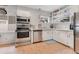 Well-lit kitchen with stainless steel appliances, white cabinets, and subway tile backsplash at 1845 Delaney Ave, Orlando, FL 32806