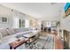 Bright living room features hardwood floors, a large sectional, and an open layout to the dining area at 1845 Delaney Ave, Orlando, FL 32806