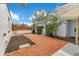 A brick patio offers a tranquil outdoor area for relaxation and entertainment, with plants and trees surrounding the perimeter at 1845 Delaney Ave, Orlando, FL 32806