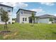 Backyard view of home, patio, and green lawn at 1904 Archer Dr, Minneola, FL 34715
