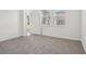 Carpeted bedroom with bright natural light and an open door showcasing outdoor views at 1904 Archer Dr, Minneola, FL 34715
