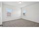 Bright bedroom featuring neutral carpet, white walls, and two windows at 1904 Archer Dr, Minneola, FL 34715