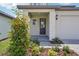 Inviting front porch with stone accents, a stylish front door, and manicured landscaping at 1904 Archer Dr, Minneola, FL 34715