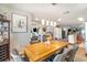 Bright dining room with a wooden table, modern pendant lighting, and views into the kitchen and living areas at 1993 Excalibur Dr, Orlando, FL 32822