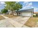 Well-maintained single-story house with a two-car garage and a mature tree in the front yard, providing shade and character at 1993 Excalibur Dr, Orlando, FL 32822