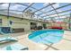 Backyard pool with a screened-in enclosure, lounge chairs, and a built-in patio area at 1993 Excalibur Dr, Orlando, FL 32822