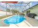Sparkling pool in screened enclosure with patio furniture and manicured lawn at 1993 Excalibur Dr, Orlando, FL 32822
