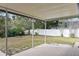 View of the partially-covered back patio, overlooking the backyard and wooded area at 2028 Sussex Rd, Winter Park, FL 32792