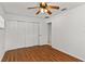 Bright bedroom with wood-look floors, ceiling fan, and a closet with folding doors at 2028 Sussex Rd, Winter Park, FL 32792