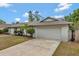 Attached garage and driveway of this single-story home with a well-maintained lawn at 2028 Sussex Rd, Winter Park, FL 32792
