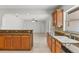 Open kitchen layout with granite countertops, wood cabinetry, and view to a large open living space at 2028 Sussex Rd, Winter Park, FL 32792