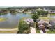 A serene aerial view reveals a home nestled by a tranquil lake, enhanced by lush landscaping and neighborhood charm at 2260 The Oaks Blvd, Kissimmee, FL 34746
