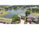 Aerial view of a lakeside home with a lush green lawn and community at 2260 The Oaks Blvd, Kissimmee, FL 34746