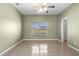 This bedroom features tile floors, a ceiling fan and a view of the community lake at 2260 The Oaks Blvd, Kissimmee, FL 34746