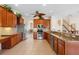 Warm kitchen with stainless steel appliances, wood cabinetry, granite counters, and tile flooring at 2260 The Oaks Blvd, Kissimmee, FL 34746