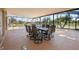 The screened-in lanai offers ample seating with a table and chairs, perfect for relaxing by the pool and lake views at 2260 The Oaks Blvd, Kissimmee, FL 34746
