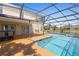 Sparkling screened-in pool with covered patio and lake view at 2260 The Oaks Blvd, Kissimmee, FL 34746