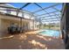 This covered pool and patio area features a pool and an outdoor dining set at 2260 The Oaks Blvd, Kissimmee, FL 34746