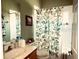 Bright bathroom with a stylish vanity, decorative seashells shower curtain, and updated fixtures at 24125 Peekskill St, Leesburg, FL 34748