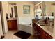 Well-lit bathroom featuring double vanities, a soaking tub, and modern fixtures at 24125 Peekskill St, Leesburg, FL 34748
