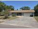 Ranch style home with a light colored exterior, an attached garage, and mature landscaping at 2523 Falkner Rd, Orlando, FL 32810