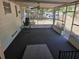 Enclosed screened porch with dark carpeting, ceiling fan, and a view of the backyard at 2523 Falkner Rd, Orlando, FL 32810