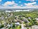 A picturesque aerial showcases lush landscaping, a lake, and other beautiful homes in a lovely neighborhood at 2525 Venetian Way, Winter Park, FL 32789