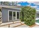 A modern home features an outdoor patio with tiled flooring and large sliding glass doors for natural light at 2525 Venetian Way, Winter Park, FL 32789