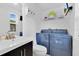 Cozy bathroom featuring modern blue washer and dryer, a built in shelving, and an efficient vanity at 2525 Venetian Way, Winter Park, FL 32789