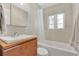 Bright bathroom featuring a combination tub and shower with a window, modern vanity, and neutral toned tile at 2525 Venetian Way, Winter Park, FL 32789