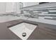 Bathroom vanity and white vessel sink set in gray countertop with modern fixtures at 2525 Venetian Way, Winter Park, FL 32789
