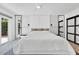 Bright, modern bedroom with a large bed, unique lighting fixtures, and access to the outdoors at 2525 Venetian Way, Winter Park, FL 32789