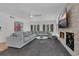 Bright living space showcasing sectional couch, stone fireplace, and multiple windows for natural light at 2525 Venetian Way, Winter Park, FL 32789