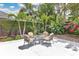 Outdoor patio space featuring a table with seating surrounded by tropical landscaping at 2525 Venetian Way, Winter Park, FL 32789