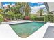 Relaxing backyard featuring a sparkling in-ground pool, lush tropical landscaping, and an inviting outdoor seating area at 2525 Venetian Way, Winter Park, FL 32789