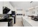 Modern white kitchen featuring stainless steel appliances, gray backsplash and a large kitchen island at 2680 Nottel Dr, St Cloud, FL 34772