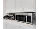 Kitchen counter showcasing stainless steel microwave and espresso machine atop white cabinets at 2680 Nottel Dr, St Cloud, FL 34772