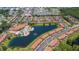 Aerial view showcases the community with its pool, clubhouse, and surrounding homes along the lake at 2718 Bushman Dr, Kissimmee, FL 34746