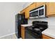Kitchen with stainless steel microwave, black appliances, and ample cabinet space at 2718 Bushman Dr, Kissimmee, FL 34746