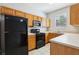 Functional kitchen featuring wood cabinets and black appliances at 2718 Bushman Dr, Kissimmee, FL 34746