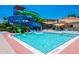 Community pool area featuring a waterslide, splash pool, and lounge seating on a sunny day at 2718 Bushman Dr, Kissimmee, FL 34746