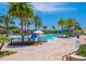 Expansive community pool with palm trees, umbrellas, lounge chairs, and a waterslide feature at 2718 Bushman Dr, Kissimmee, FL 34746