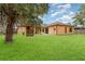 Spacious backyard with a wooden playset, lush green lawn, and mature shade trees at 2739 Village Pine Ter, Orlando, FL 32833