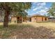 Expansive backyard featuring a large lawn, mature trees, a playset, and a home with a neutral color palette at 2739 Village Pine Ter, Orlando, FL 32833