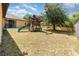 Large backyard with mature tree, wooden playset with swings, and a well-maintained lawn at 2739 Village Pine Ter, Orlando, FL 32833