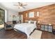 Cozy bedroom with wood-look accent wall, tile flooring, and bright natural light at 2739 Village Pine Ter, Orlando, FL 32833