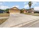 Front exterior of a one story home with a large driveway and mature palm trees in a friendly neighborhood at 2739 Village Pine Ter, Orlando, FL 32833