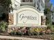 Stone Georgetown at Celebration community sign nestled among colorful flowers and shrubbery at 312 Grand Bay Ln, Celebration, FL 34747