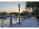 Waterfront view of the community with a walking path, lamp posts, and lakeside sunset at 312 Grand Bay Ln, Celebration, FL 34747